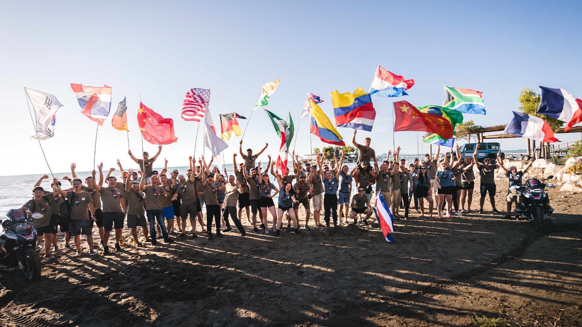 Ein Gruppenbild, aufgenommen am Strand, aller Teilnehmer aus vielen Nationen der Int. GS Trophy 2022 in Albanien