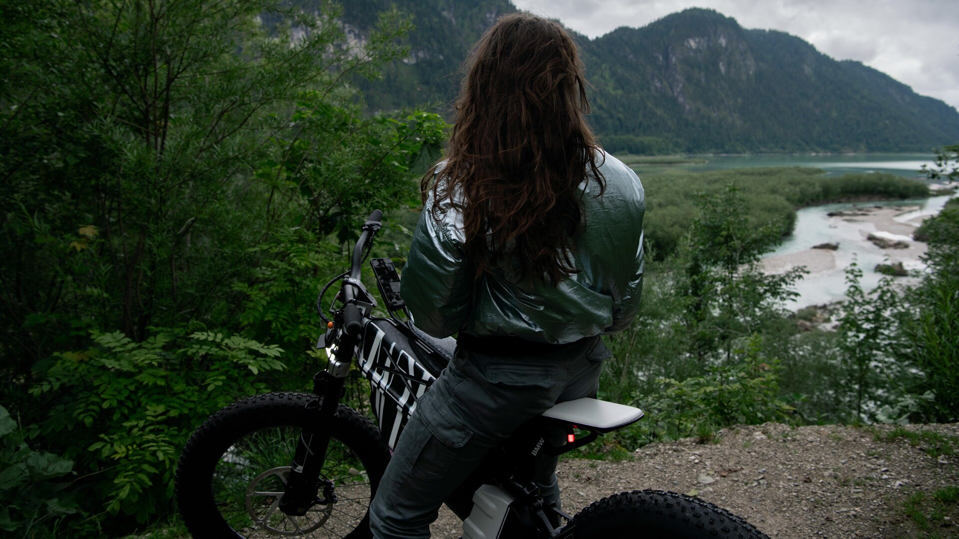 Frau auf Vision AMBY sitzend mit Blick auf einen Bergsee.