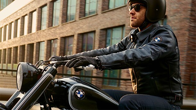 Ein Fahrer sitzt lässig auf dem Motorrad und trägt dabei die Lederjacke FlatTwin für Herren.